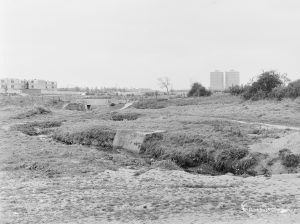 Dagenham Village housing development, showing undeveloped land adjoining east end of Ballards Road, continuing to south, with two tower blocks in background, 1972