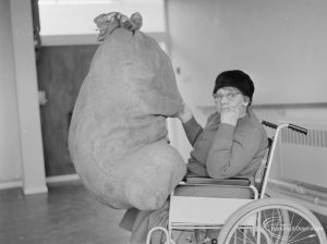 Leys Avenue Occupational Centre for the Physically Handicapped, Dagenham, showing female wheelchair user holding large sack on lap, 1972