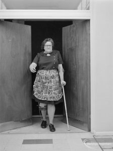 Leys Avenue Occupational Centre for the Physically Handicapped, Dagenham, showing woman emerging through doors from darkened room, 1972