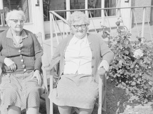 Welfare Department, taken for Social Services Dagenham Town Show display, showing two women sitting in garden chairs outside The Lawns Old People’s Home for Senior Citizens, 1972