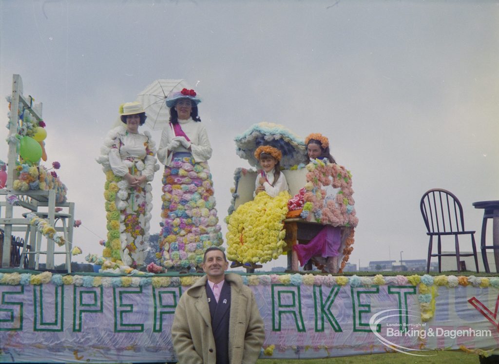 Dagenham Town Show 1972 at Central Park, Dagenham, showing women and girls dressed in long floral dresses and hats and standing on a supermarket float, 1972