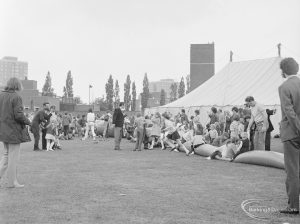 Dagenham Town Show 1972 at Central Park, Dagenham, showing children playing on giant inflated tube, with Fire Station and marquee in background, 1972