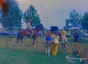 Dagenham Town Show 1973 at Central Park, Dagenham, showing Horse Trials, with two girls watching mounted rider in paddock, 1973