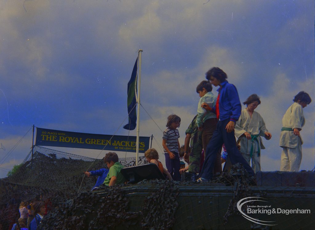 Dagenham Town Show 1973 at Central Park, Dagenham, showing Army display with boys on top of and inside Royal Green Jackets camouflaged tank, 1973