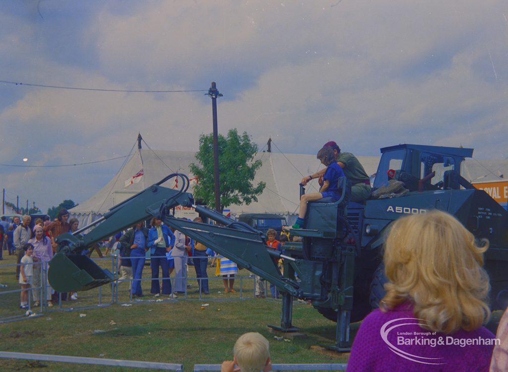 Dagenham Town Show 1973 at Central Park, Dagenham, showing Army display with spectators and boy being shown operation of mechanical digger, 1973