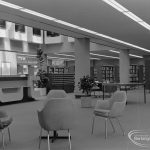 New Barking Central Library, Axe Street, Barking, showing armchairs, bookcases and counter in Lending section, 1974