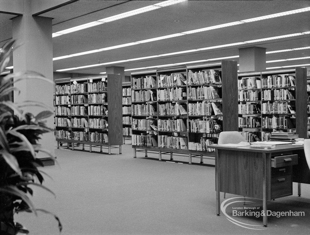 New Barking Central Library, Axe Street, Barking, showing bookcases and Librarian’s desk in Lending section, 1974
