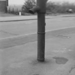 Old iron pump in pavemen...