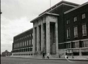 The Civic Centre, Dagenham, showing front of building, and with family walking by, 31 January 1965
