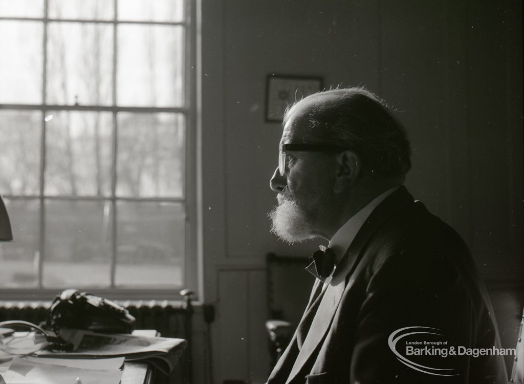 Dagenham Borough Librarian John Gerald O’Leary sitting at desk in study, 2 February 1965