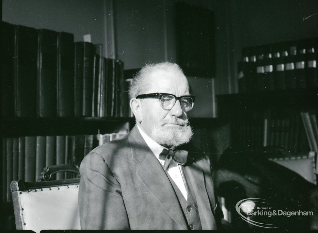 Dagenham Borough Librarian John Gerald O’Leary in study, with rows of books behind him, 2 February 1965