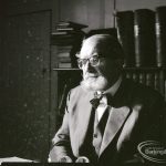 Dagenham Borough Librarian John Gerald O’Leary in study, with rows of books behind him, 2 February 1965
