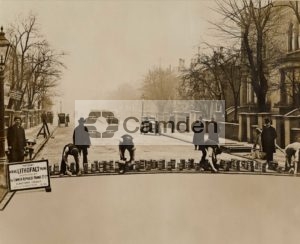 View of workmen laying new paving slabs in Belsize Road