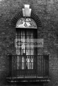 Detail of balcony, window and lunette depicting St George and the dragon