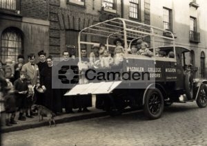 Nursery school children aboard Magdalen College Mission van outside Mission building