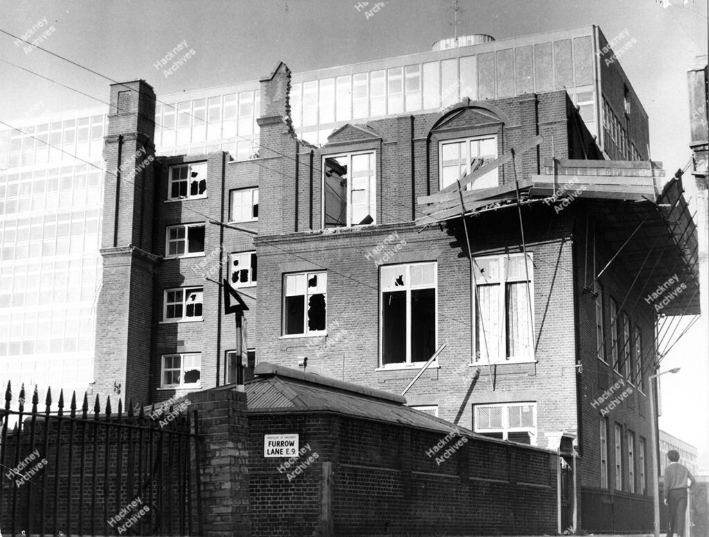 The old Upton House school buildings in course of demolition, and new buildings in background; looking south west along Homerton Row from junction with Furrow Lane.   c.1966
