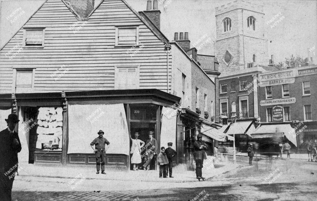 View looking north from junction of Mare Street and Amhurst Road, showing Hackney Tower and corner of Eight Bells pub, c.1868.
