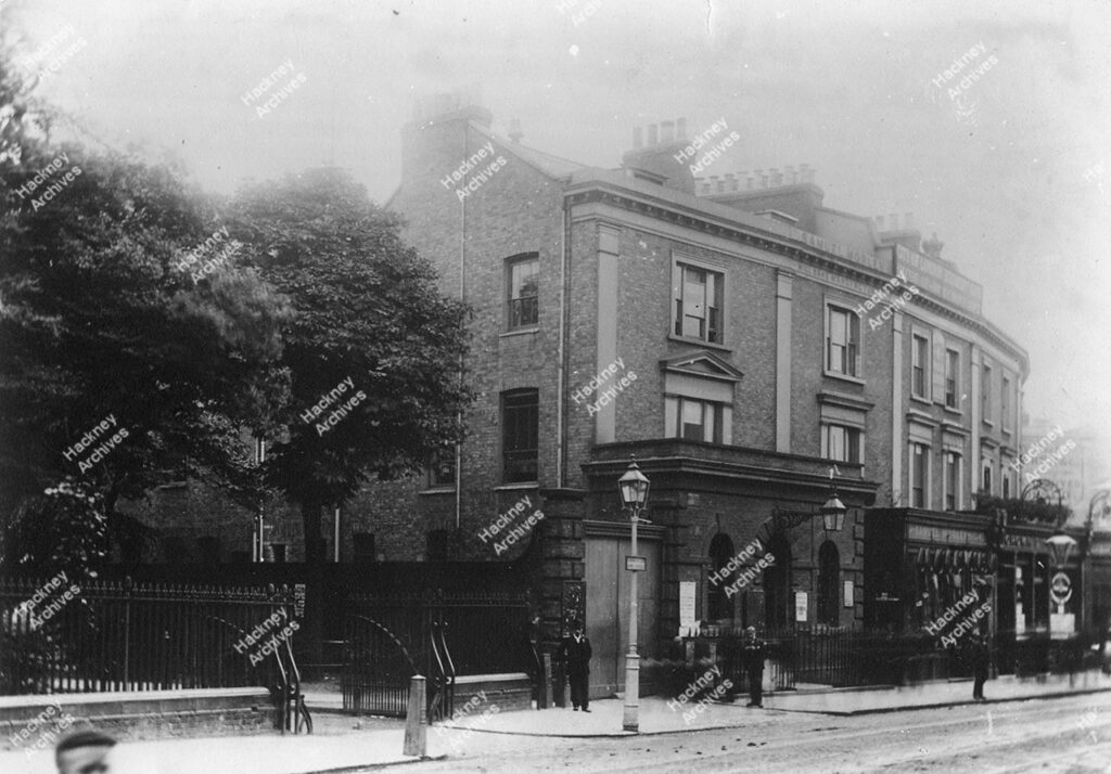 Mare Street, east side, opposite Dalston Lane; showing Crown Tavern, the old Police Station and corner of St. John’s Church gardens, c.1880.