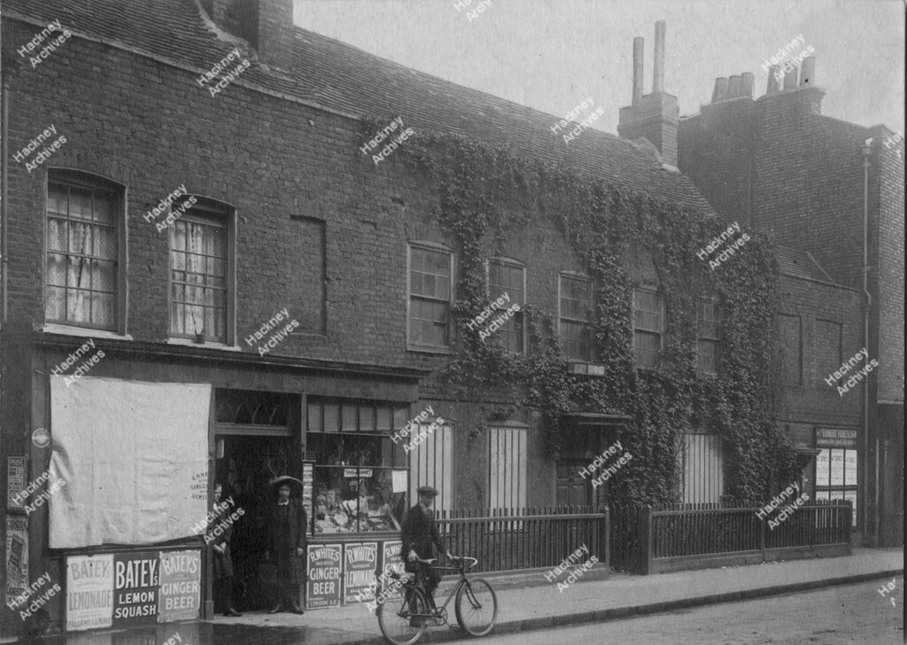 Stoke Newington Church Street. Includes Pishey Thompson’s House and Ye Olde Toye Shop. Boy with bicycle, c.1900.