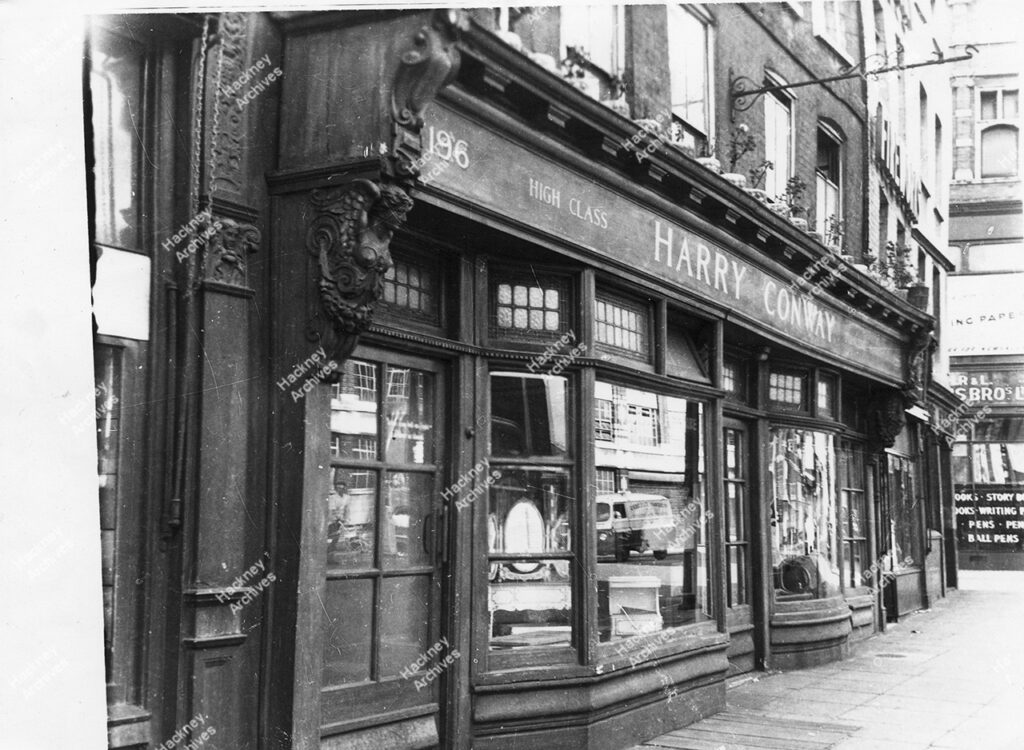 Harry Conway reproduction furniture maker, west side, 196 Shoreditch High Street opposite Bethnal Green Road with The Eagle pub next door, c.1960.