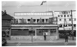 Exterior of The Hackney and Kingsland Gazette, corner of Kingsland Road and Richmond Road. Includes adverts on office building, c.1905.