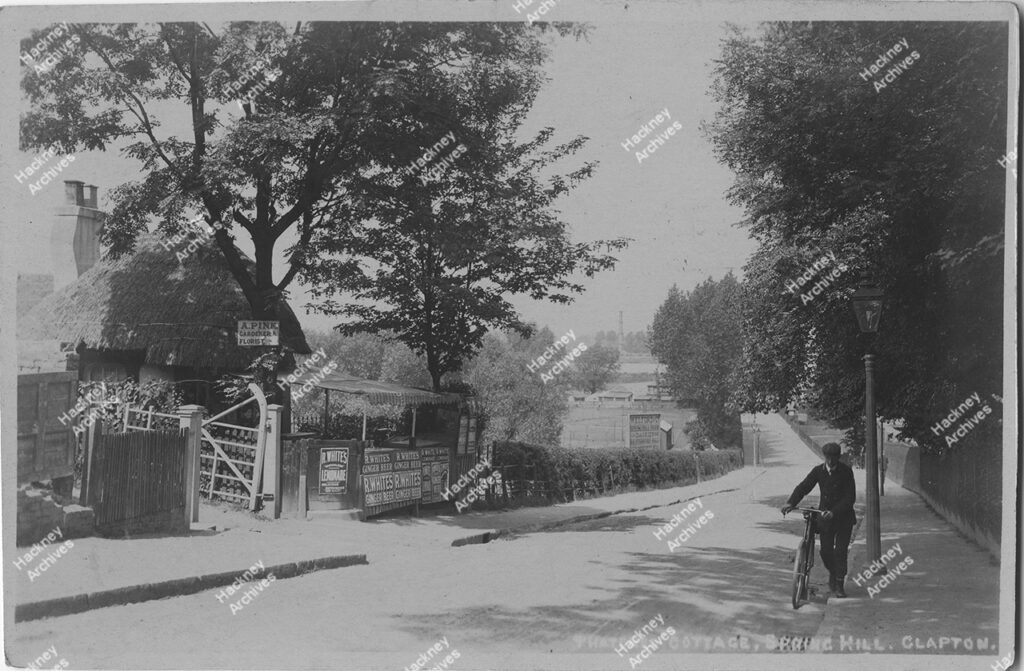 Thatched cottage, Spring Hill, Clapton, Hackney. Looking east down the hill. Includes a thatched cottage, cyclist and fields in distance, c.1920.