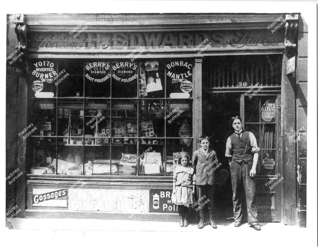 H. Edwards provision stores, grocers, 20 Morpeth Road, south Hackney.Includes Lily, Albert and Harry Edwards outside the shop with full window display, c.1913.