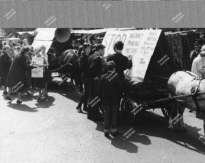 Chatsworth Road, looking south by junction with Clifden Road; meeting in protest against parking meters in Hackney. Also showing Clapton Park Tavern. 1966.