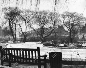 Lower Clapton pond frozen in winter. Looking north east towards Bishop Wood's Almshouses. Includes bridge, c.1965.