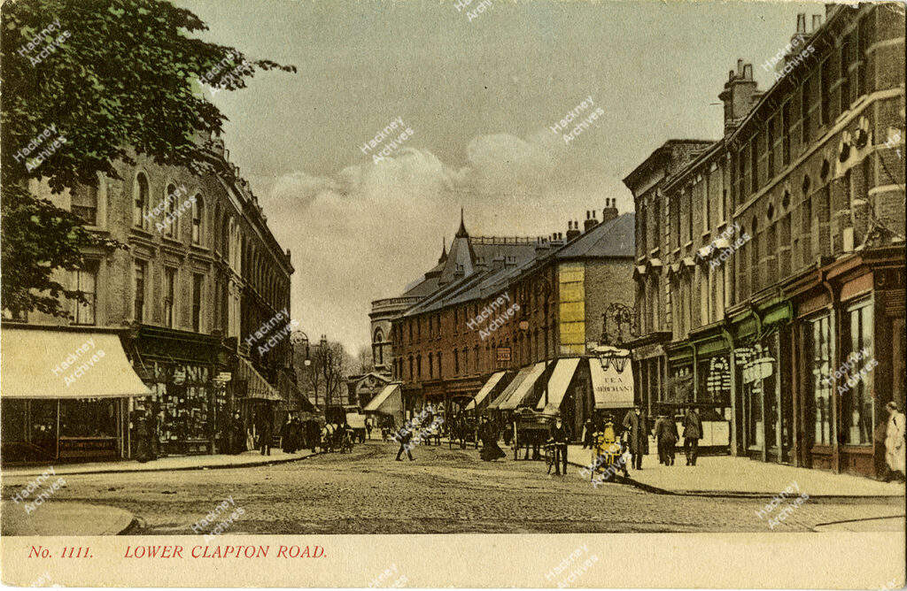 Postcard of Lower Clapton Road looking north from the junction of Lower Clapton Road, Urswick Road and Lesbia Road. Includes the Congregational Church, Clapton Park and shops, men with bicycles and horse drawn carts, c.1880.