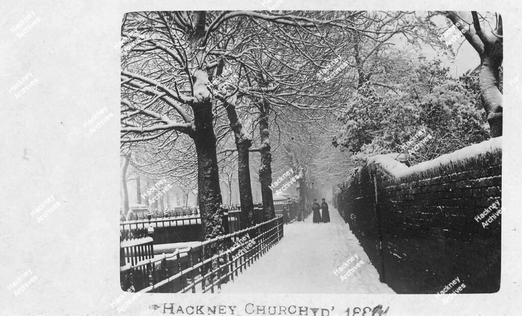 St. John at Hackney, churchyard looking east along the path at the south end of the Churchyard in the snow, c.1886.