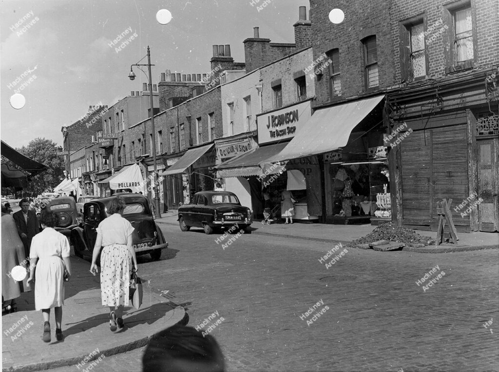 Broadway Market, London Fields,  Includes J. Robinson Bacon Shop, Pollards, Colour Vision, c.1958.