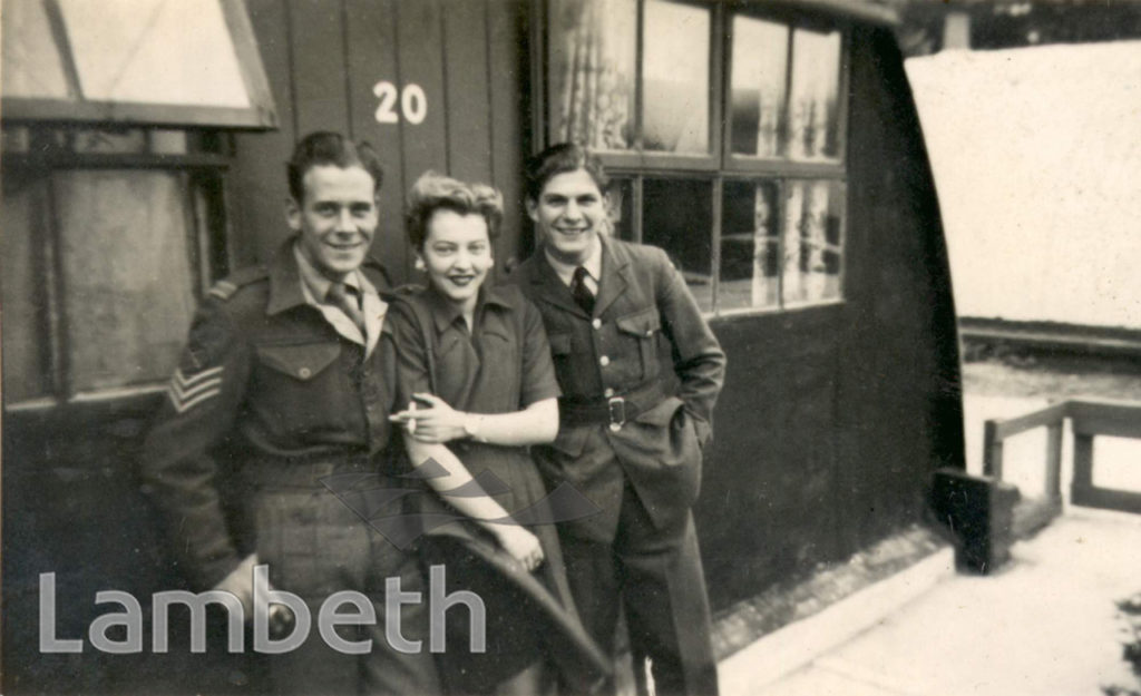 SOLDIERS OUTSIDE A WARTIME PREFAB, BRIXTON NORTH