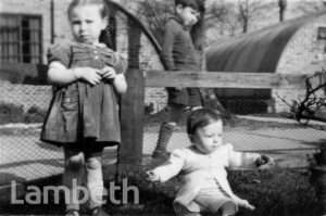 CHILDREN OUTSIDE A WARTIME PREFAB: BRIXTON NORTH