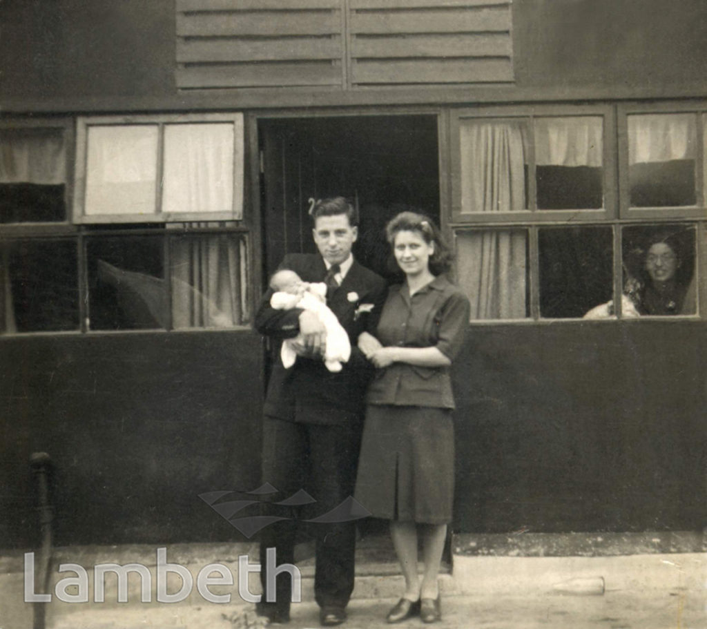 COUPLE WITH BABY OUTSIDE A WARTIME PREFAB, BRIXTON NORTH