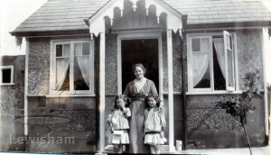 Unidentified Woman and 2 children outside a House