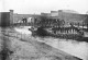 People on bridge over the River Wandle and by riverside